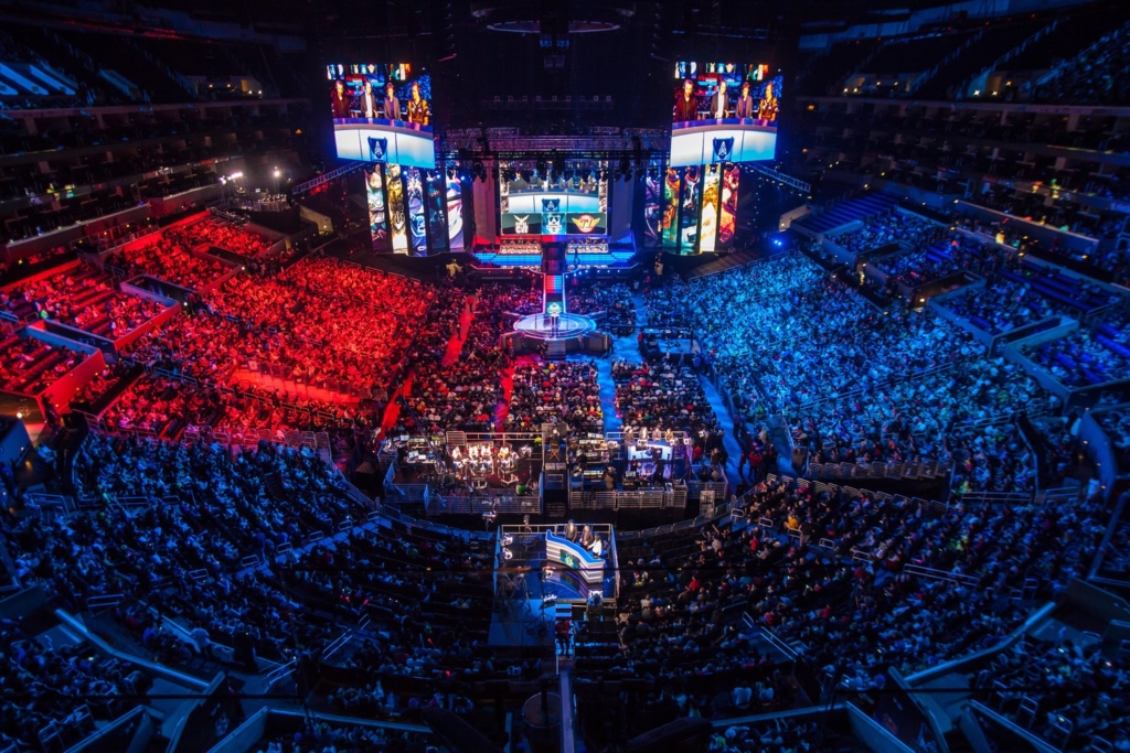 A stadium filled with spectators watching a League of Legends tournament.